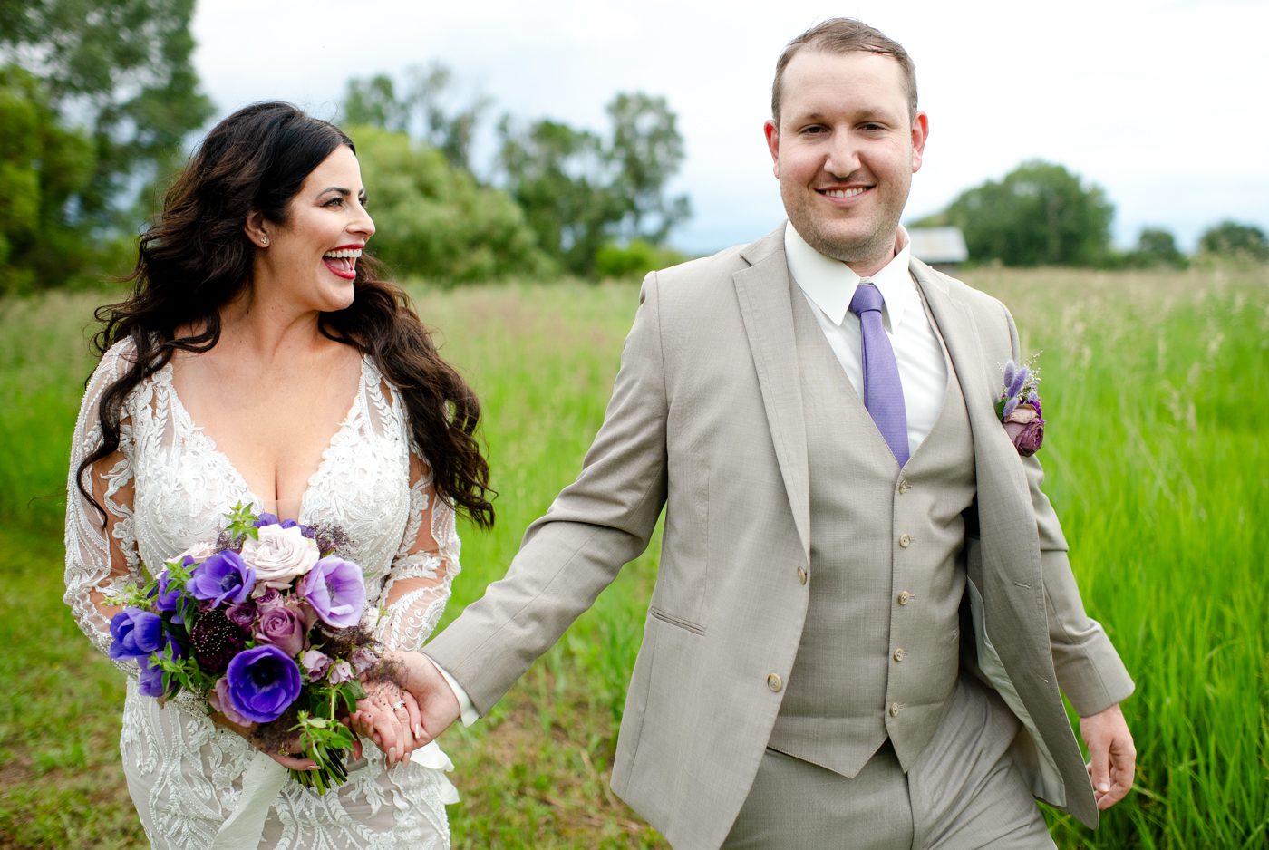 smiling-groom-walks-with-bride-in-green-field